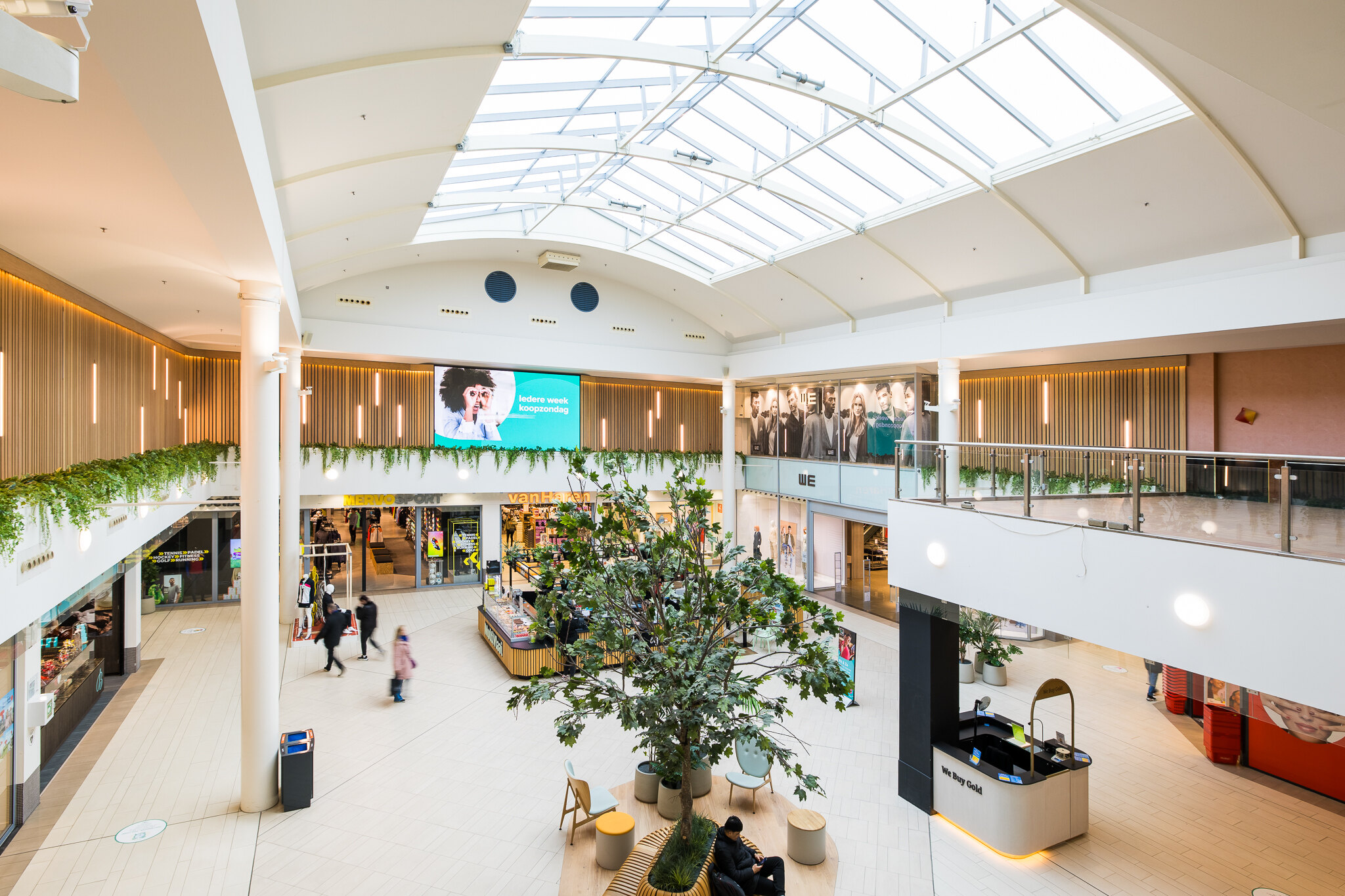 De lichte centrale hal van Winkelcentrum Roselaar met winkelend publiek